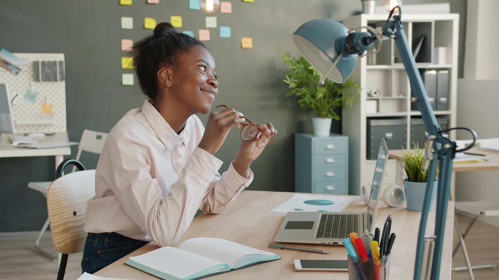 A smiling team member working at a desk in a bright office