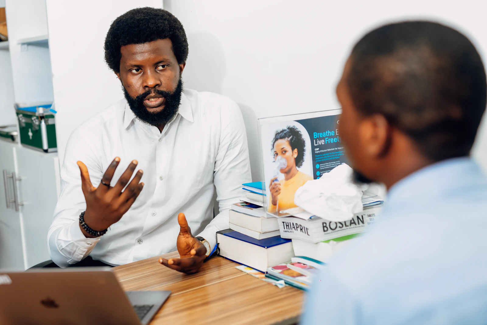A doctor explaining findings to a patient across a consulting desk